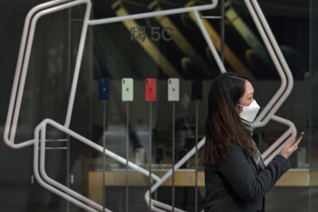 A woman passes an Apple store displaying iPhones at a shopping mall in Beijing, China. Photo: AP Photo