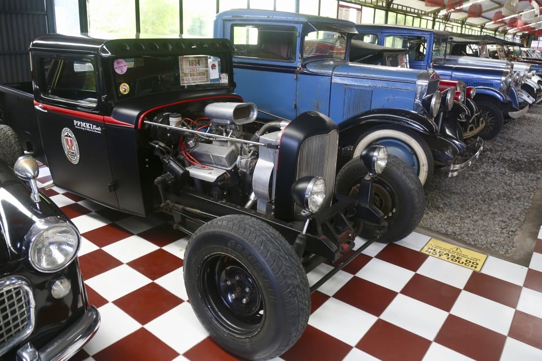 A convertible Ford V8 hot rod (left) sits among a row of classic American cars at Kebon Vintage Cars in Bali, Indonesia. Photo: Ian Neubauer