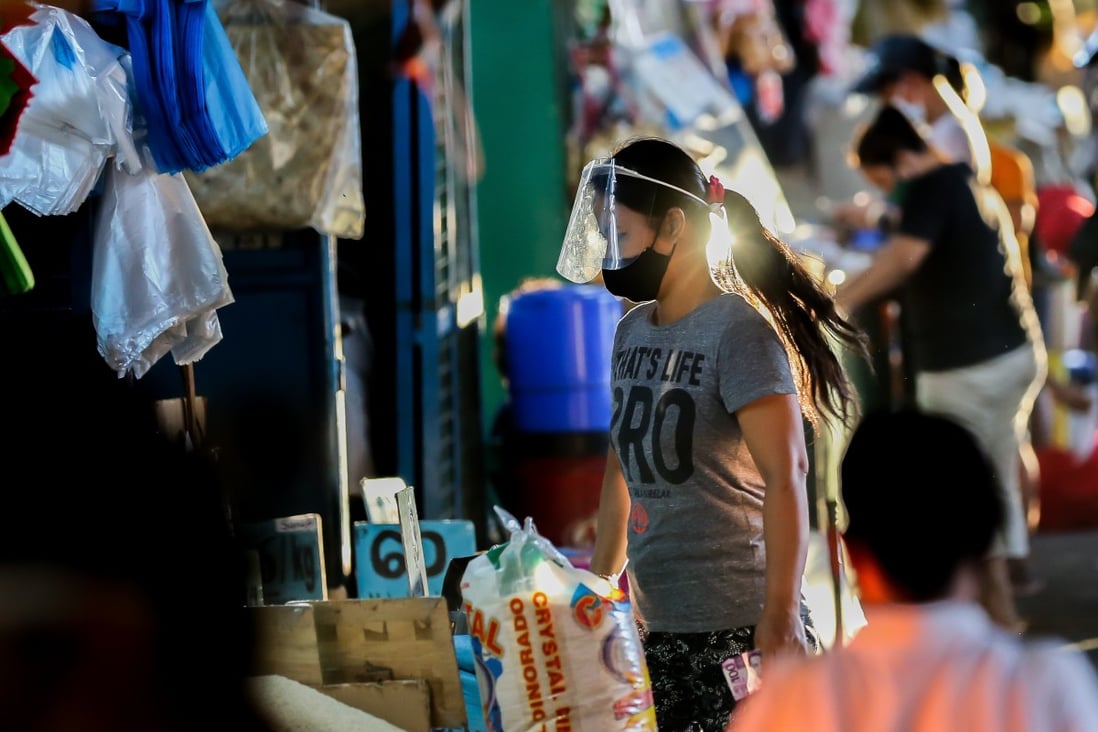 A woman wearing a face mask at a market in Manila. Photo: Xinhua