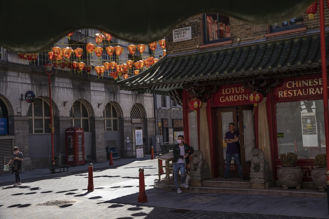 Men stand outside a closed restaurant in a deserted Chinatown in London on June 16, 2020. Racism against people of East Asian descent has increased during the pandemic. Photo: Getty Images