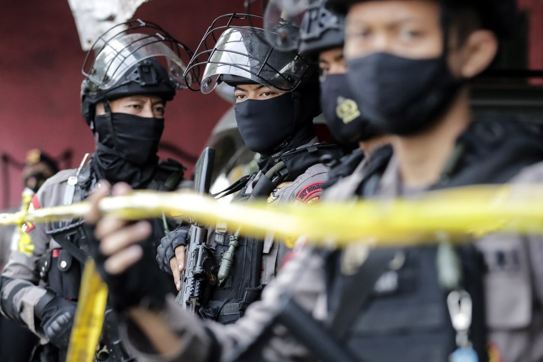 Police officers secure the area during a raid on suspected militants in Jakarta following the March 28 Makassar attack. Photo: EPA