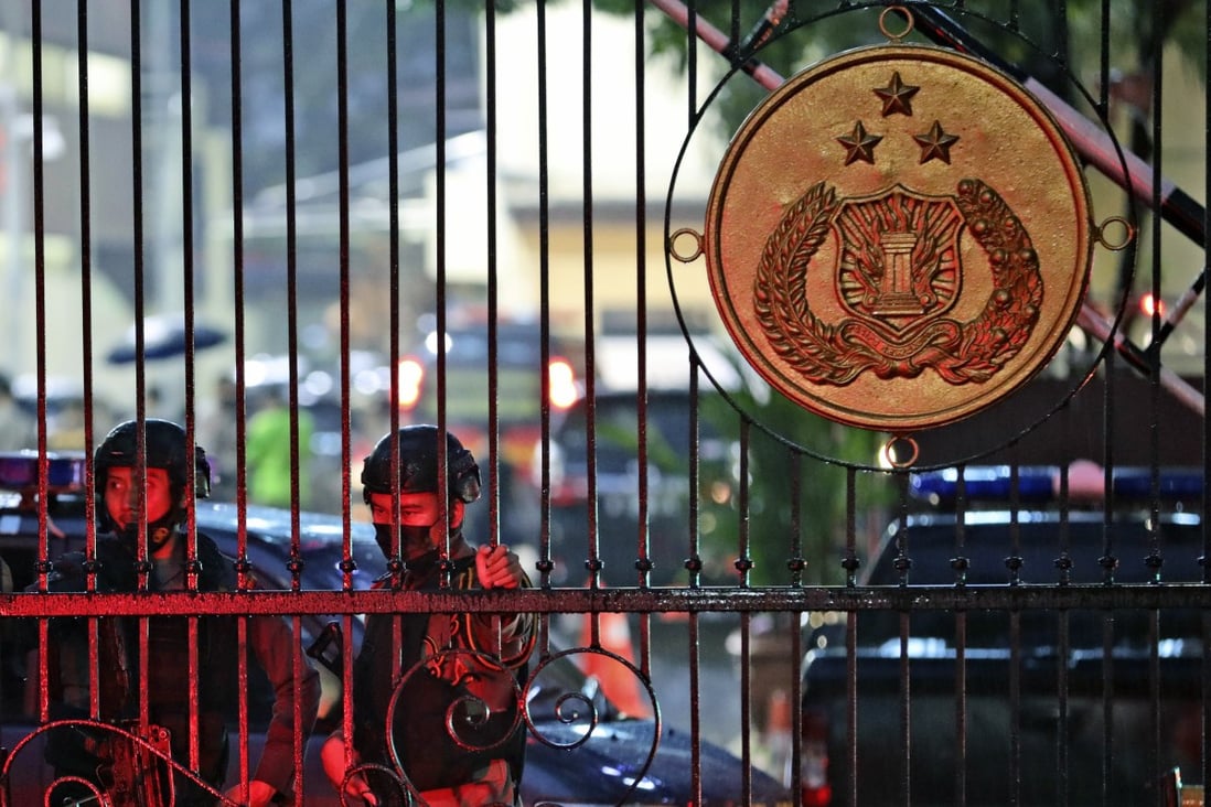 Police officers stand guard at the main gate of the National Police Headquarters in Jakarta following a suspected militant attack. Photo: AP