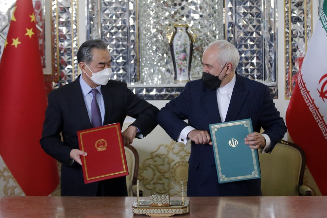 Iranian Foreign Minister Mohammad Javad Zarif (right) greets Chinese Foreign Minister Wang Yi after a document-signing ceremony in Tehran on March 27. Photo: EPA-EFE