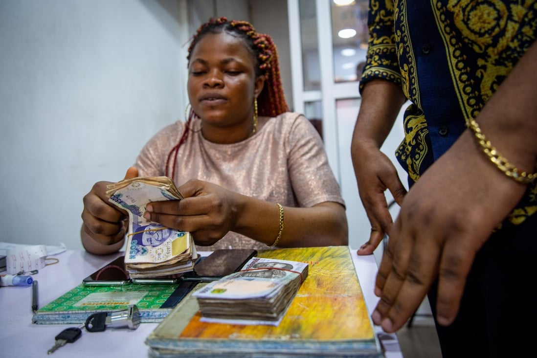 A vendor counts out Nigerian naira banknotes in Lagos, on March 29. Nigerians are contending with their highest inflation rate in four years as fears of spikes in consumer prices spread globally. Photo: Bloomberg