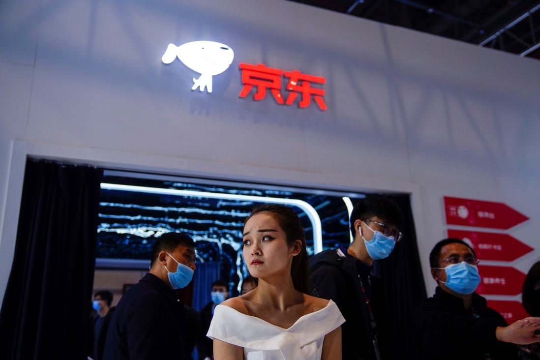 People stand under e-commerce giant JD.com’s logo at the Appliance and Electronics World Expo in Shanghai on March 23, 2021. The company’s fintech unit, JD Technology, will now run its cloud computing and artificial intelligence operations. Photo: Reuters