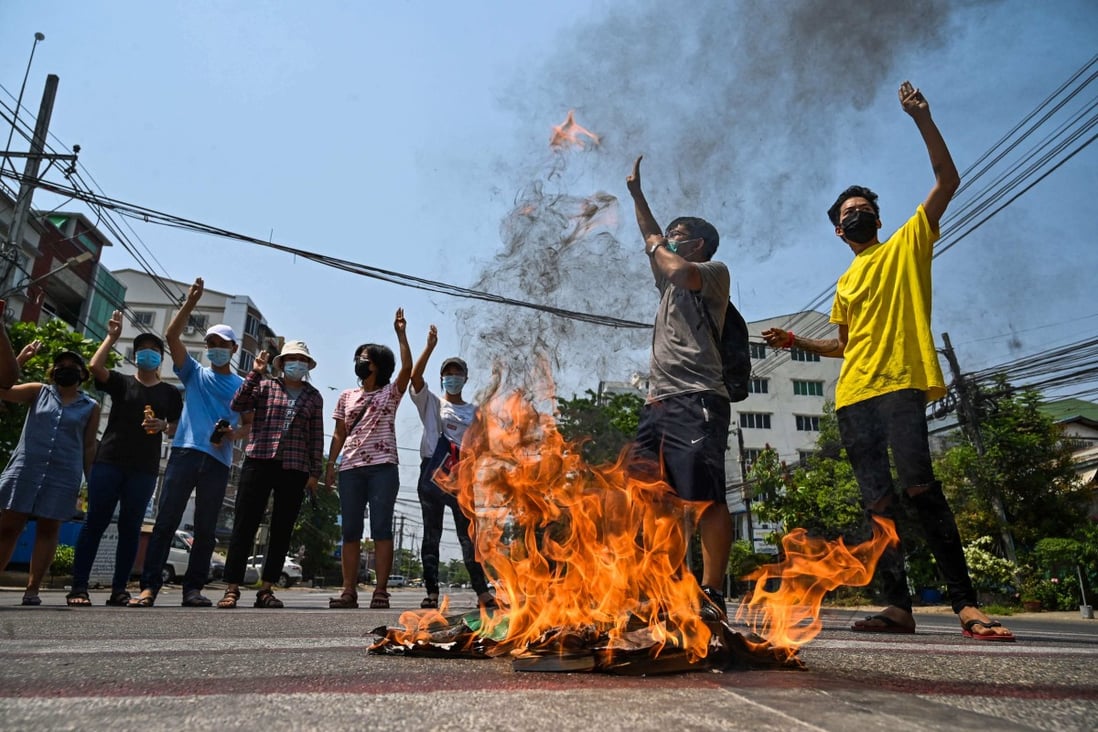 Anti-coup protesters burn copies of the 2008 constitution in Yangon. Photo: AFP
