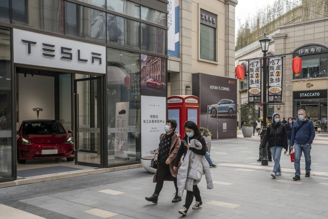 Shoppers walk past a Tesla showroom in Shanghai on March 8, 2021. Photo: Bloomberg