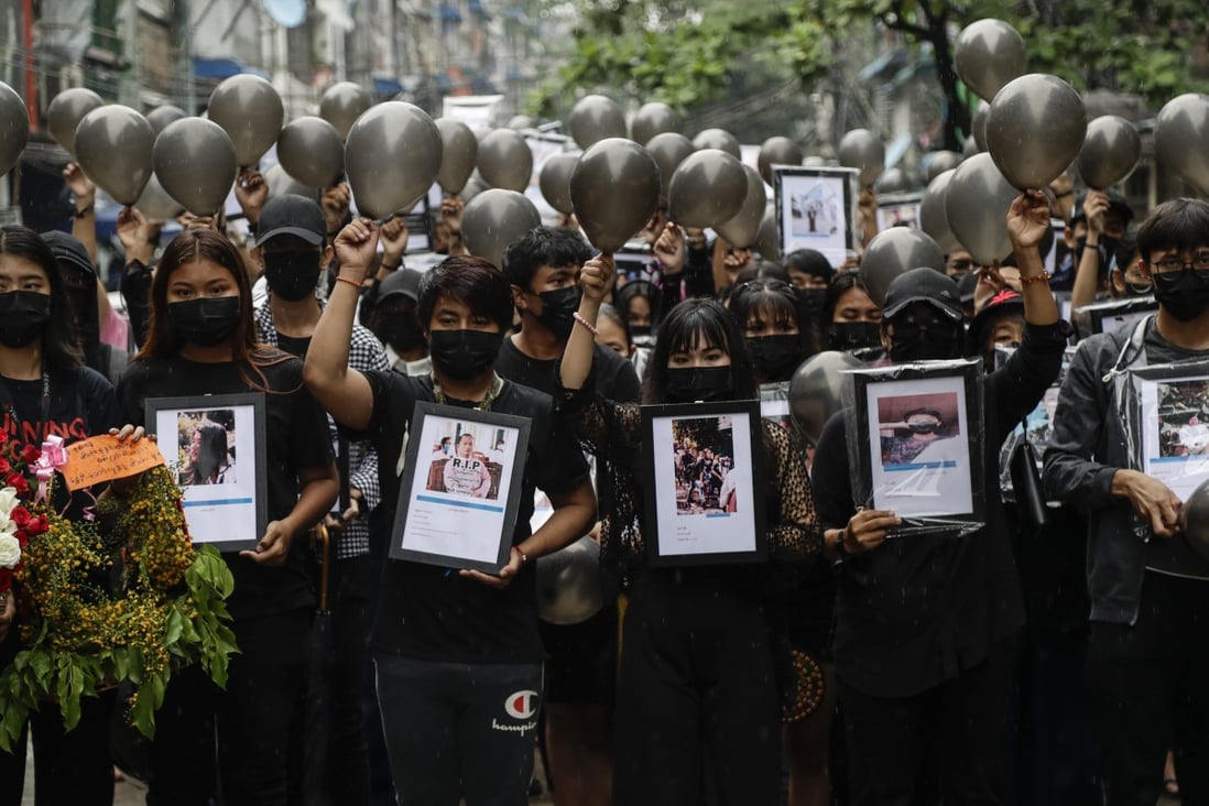 Demonstrators in Yangon on Monday hold pictures showing some of the hundreds killed during Myanmar’s ongoing anti-coup protests. Photo: EPA