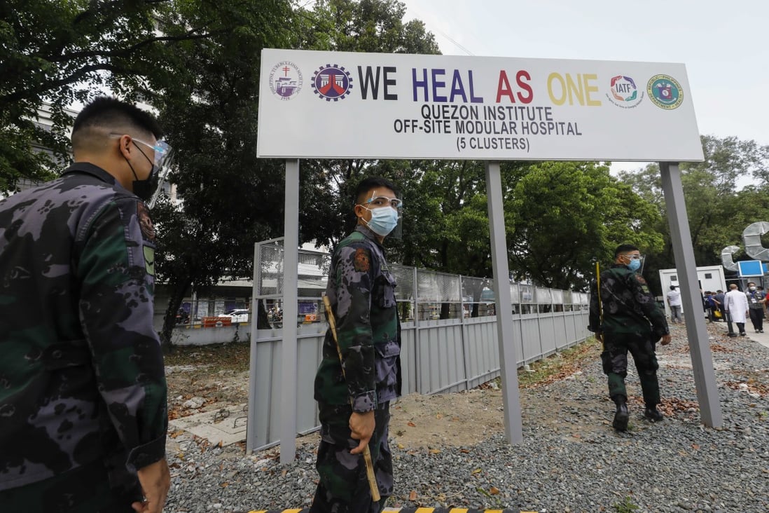 Philippine police keep watch as officials arrive at an off-site modular hospital for Covid-19 patients in Quezon City. Photo: EPA