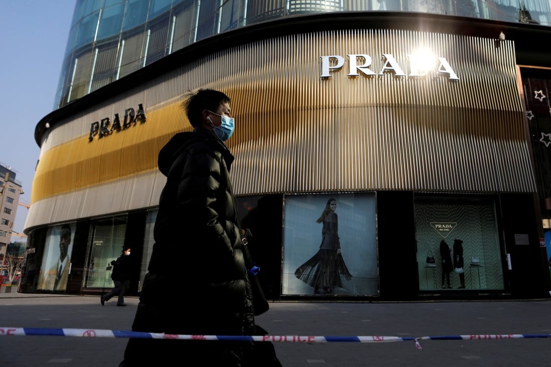 A man walks past a Prada store in Beijing, the city that according to Forbes now has the greatest number of billionaires on the planet. Photo: Reuters
