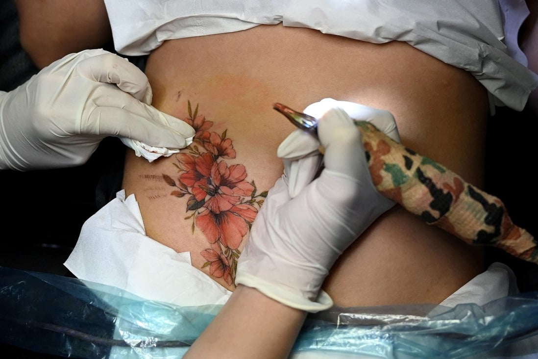 Ngoc Like inks over a customer’s scar at her studio in Hanoi. Tattoos are an art form that is still largely taboo in Vietnam. Photo: AFP