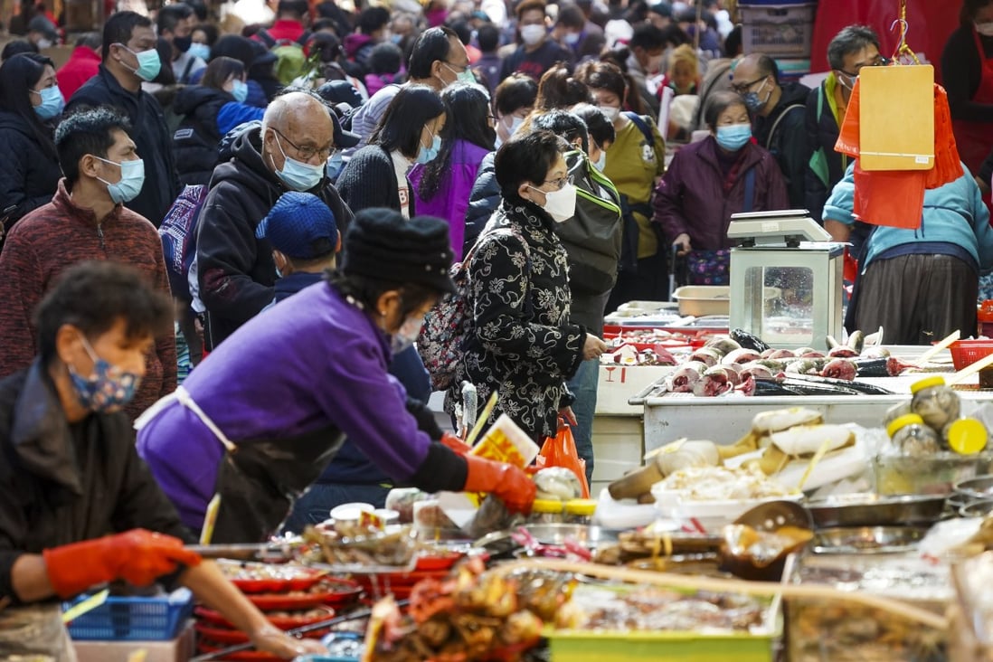 People buy food at a wet market in Wan Chai in December 2020. The e-voucher scheme should not leave behind people and stores that use cash. Photo: Felix Wong
