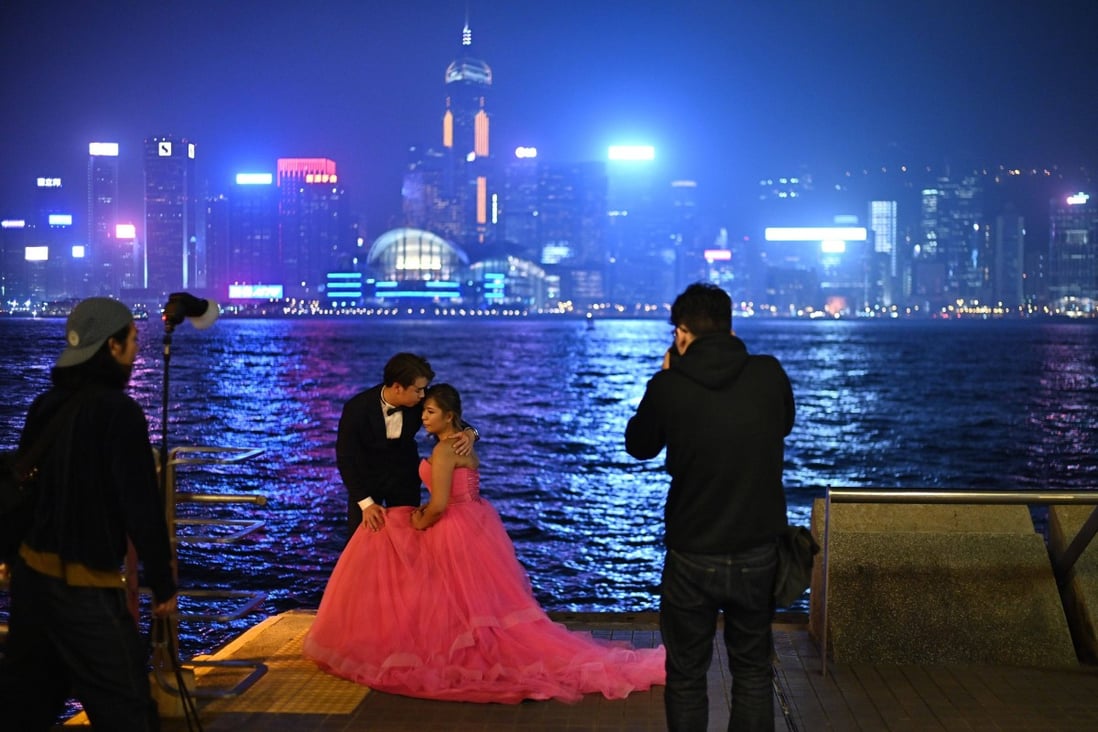 A couple pose for wedding photos by Hong Kong’s Victoria Harbour. Photo: AFP