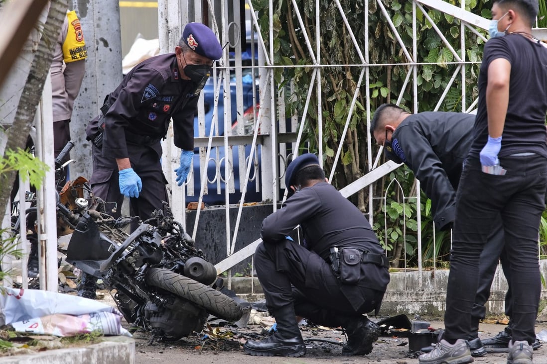 Members of a police bomb squad inspect the wreckage of a motorbike used to carry out a suicide bomb attack in South Sulawesi, Indonesia. Photo: AP