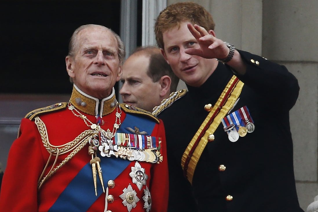 Prince Philip talks to Prince Harry on the balcony of Buckingham Palace during the Trooping The Colour parade, in London in 2014. The royal family will not wear military uniform at Philip’s funeral, in a break with tradition reportedly designed to avoid embarrassing Prince Harry, who was stripped of his honorary titles despite serving in Afghanistan when he quit royal life. Photo: AP