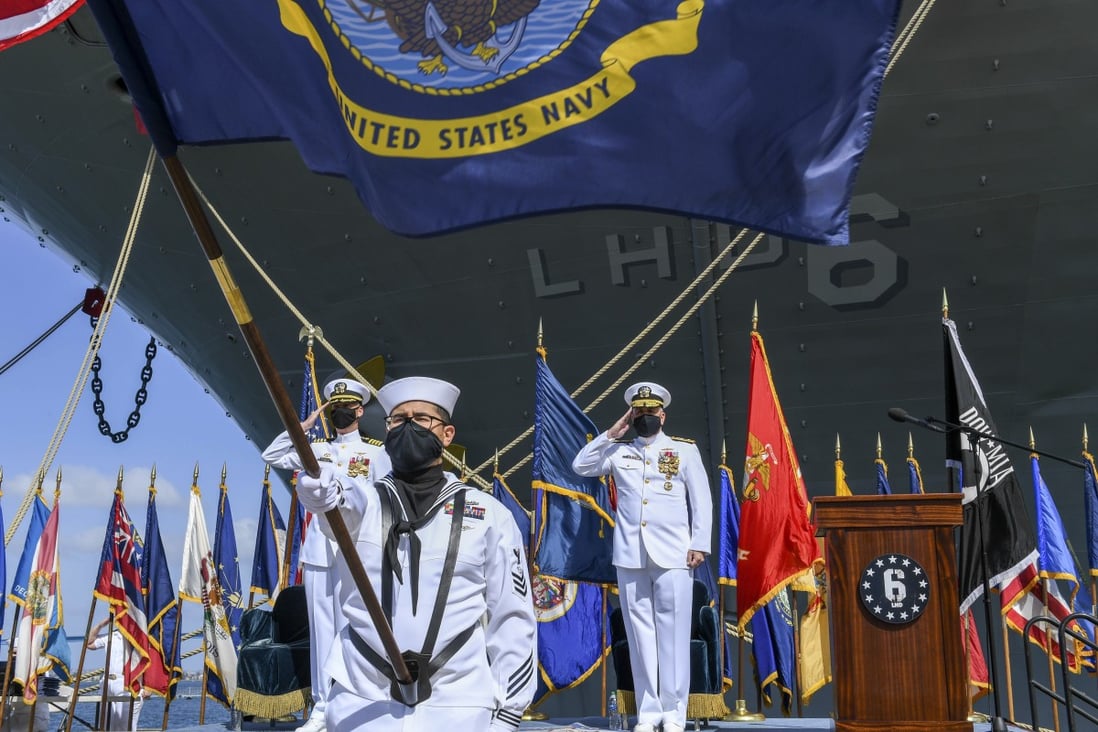 Members of the US Navy salute the ensign for colours during a decommissioning ceremony of the amphibious assault ship USS Bonhomme Richard at Naval Base San Diego on April 14, 2021. Photo: Handout via AP