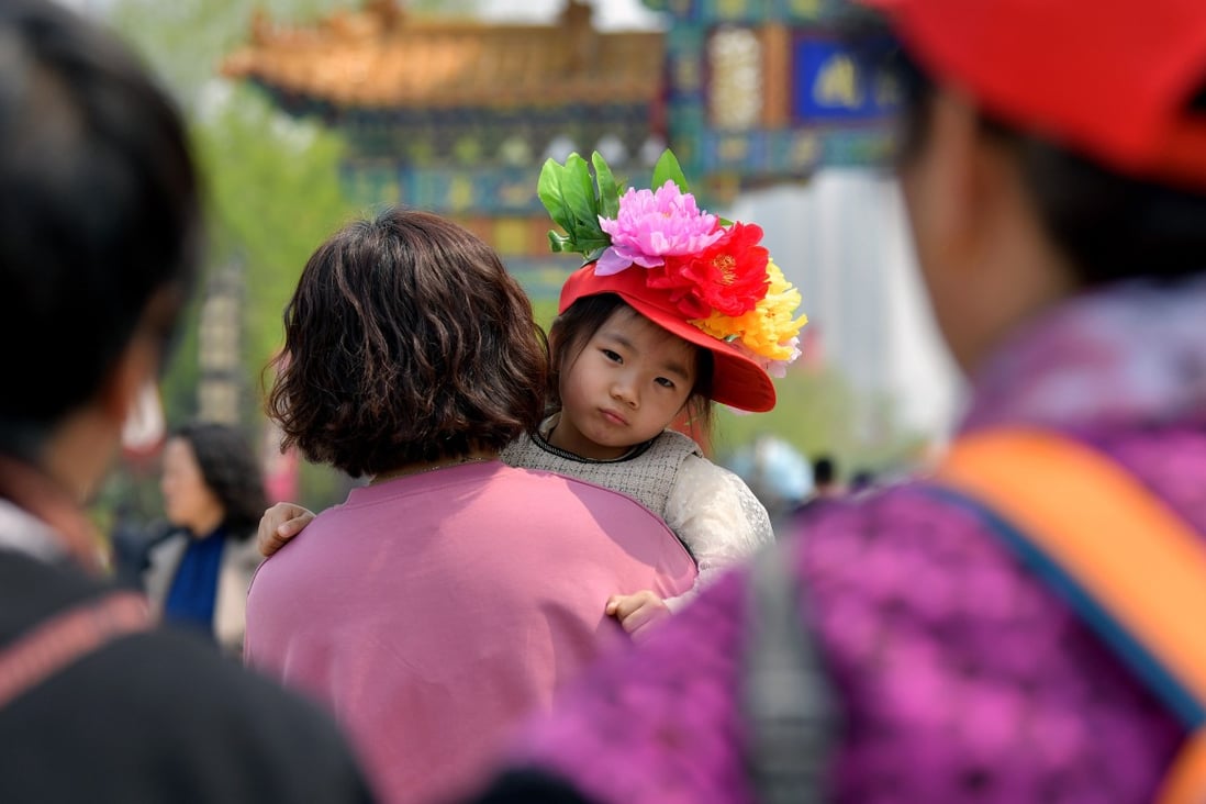 A girl wearing peony decorations visits a garden in Heze city, Shandong province, on April 8. Gender stereotypes can have an impact on a daughter’s educational achievement, which is usually a precondition for economic achievement. Photo: Xinhua