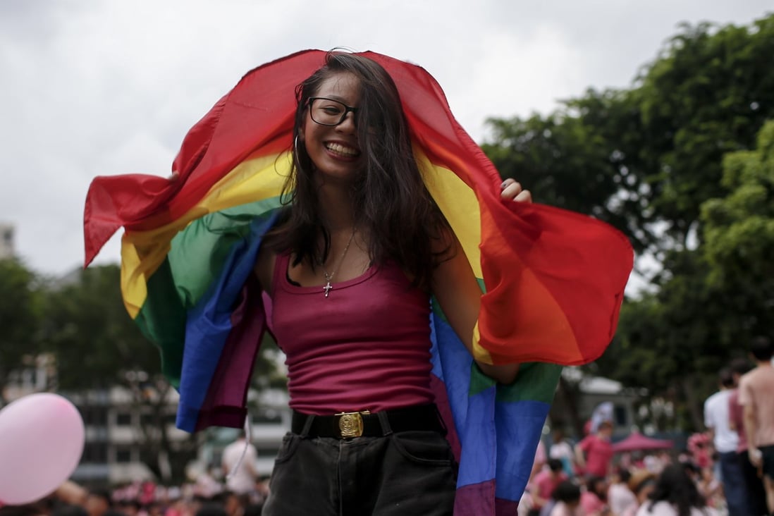 A woman dances with a rainbow flag at the Speaker’s Corner in Hong Lim Park, Singapore. Photo: EPA