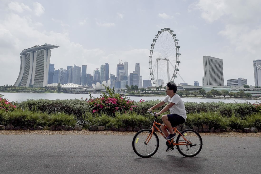 A cyclist rides past the skyline of the financial district and Marina Bay in Singapore. Quarantine-free travel with Hong Kong will start on May 26. Photo: EPA-EFE