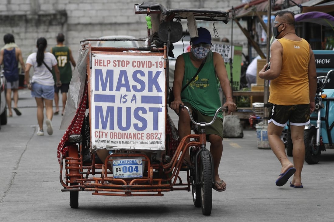A man in Manila rides his pedicab bearing a slogan to remind people to wear masks. Photo: AP