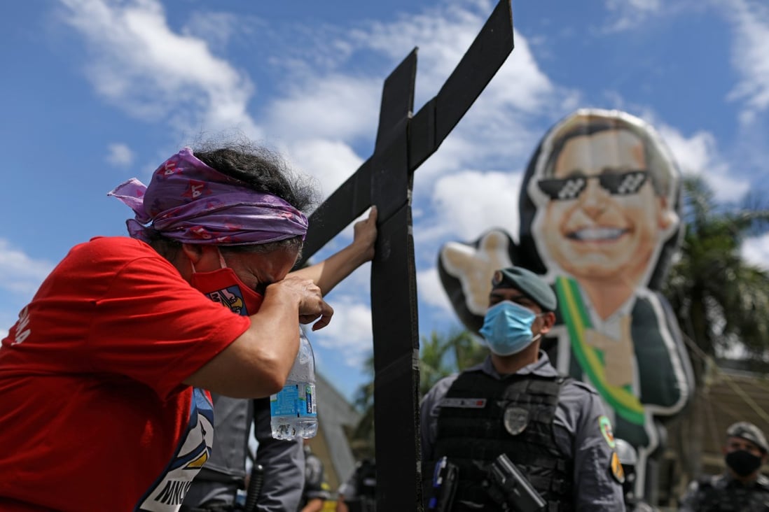 A demonstrator holds a cross during a protest against President Jair Bolsonaro in Manaus, Brazil. Photo: Reuters