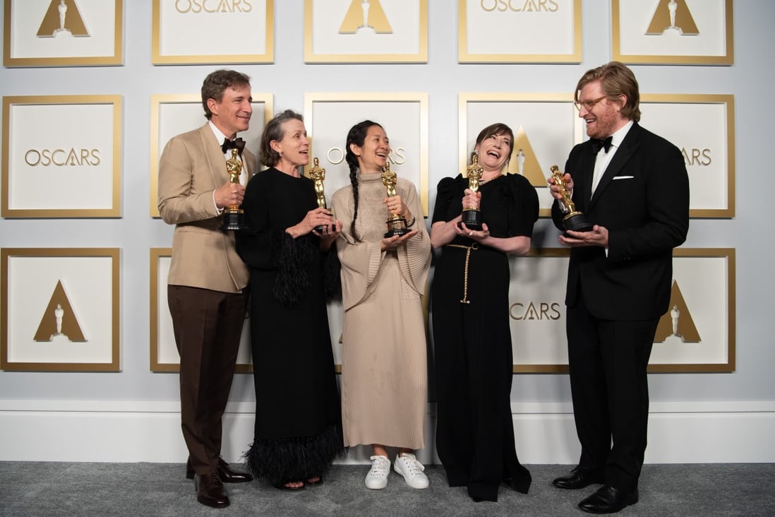 Nomadland director Chloe Zhao (centre), with cast members Peter Spears and Frances McDormand (left) and producers Mollye Asher and Dan Janvey (right), posing for photos on April 25. Zhao went for an understated look at the Oscars. Photo: Ampas / PA Media / dpa