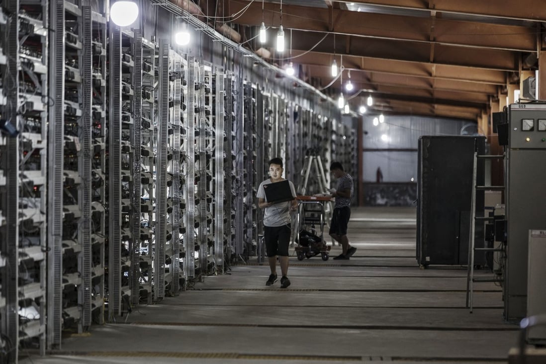 Technicians inspect cryptocurrency mining machines at a facility in Ordos, a city in Inner Mongolia. Photo: Bloomberg