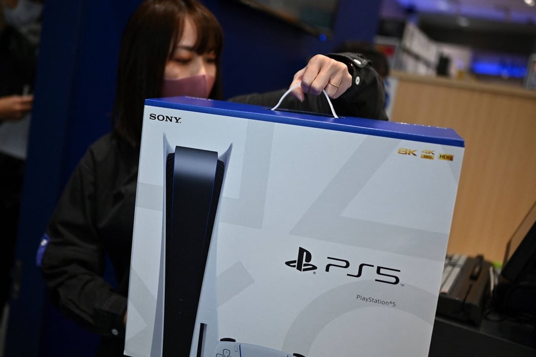 An employee prepares the new Sony PlayStation 5 gaming console for a customer on the first day of its launch, at an electronics shop in Kawasaki, Japan on November 12, 2020. Sony announced the launch of its next-generation console in mainland China on Thursday. Photo: AFP