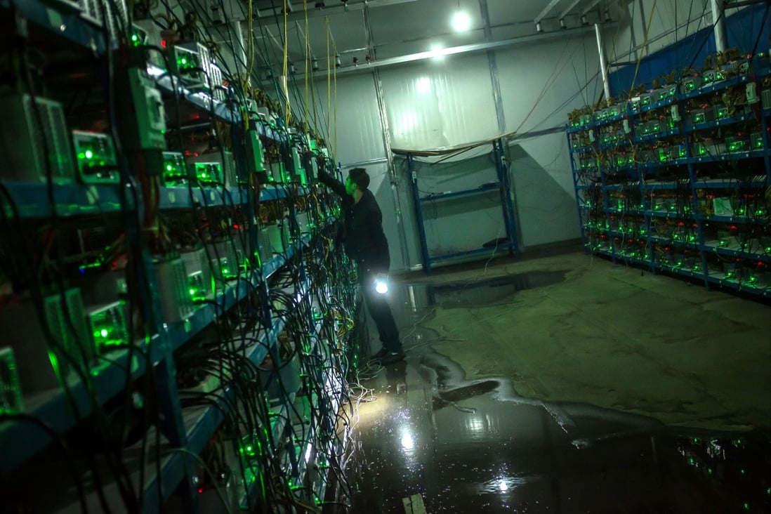 A bitcoin miner inspects a malfunctioning mining machine during his night shift at a facility in Sichuan province on September 26, 2016. While China is home to most of the bitcoin network's computational power, Beijing has been cracking down mining recently over concerns related to financial stability and energy use. Photo: EPA