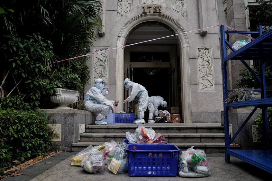 Workers in protective clothing deliver food to residents locked down in Guangzhou. Photo: Reuters