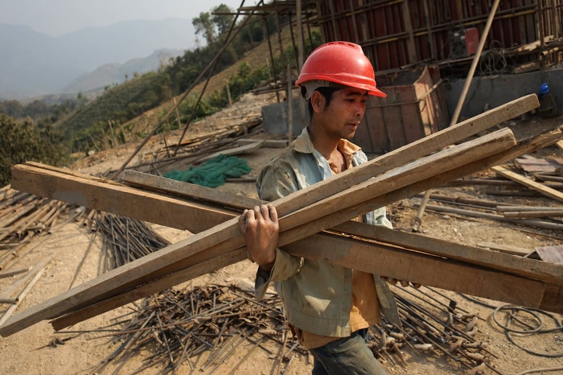 A Chinese worker carries materials for a rail line linking China to Laos. File photo: AFP