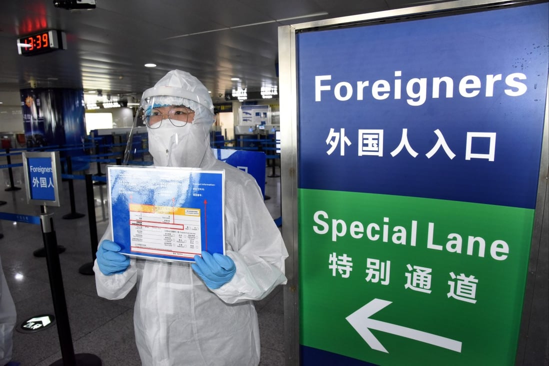 A worker reminds foreign visitors to fill in an arrival card at an airport in China. File photo: Xinhua