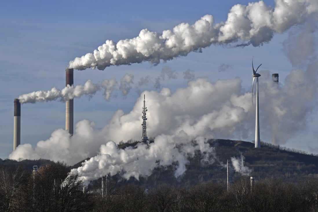 Emissions from a Uniper energy company coal-fired power plant and a BP refinery billow towards a wind turbine in Gelsenkirchen, Germany, on January 16, 2020. Photo: AP