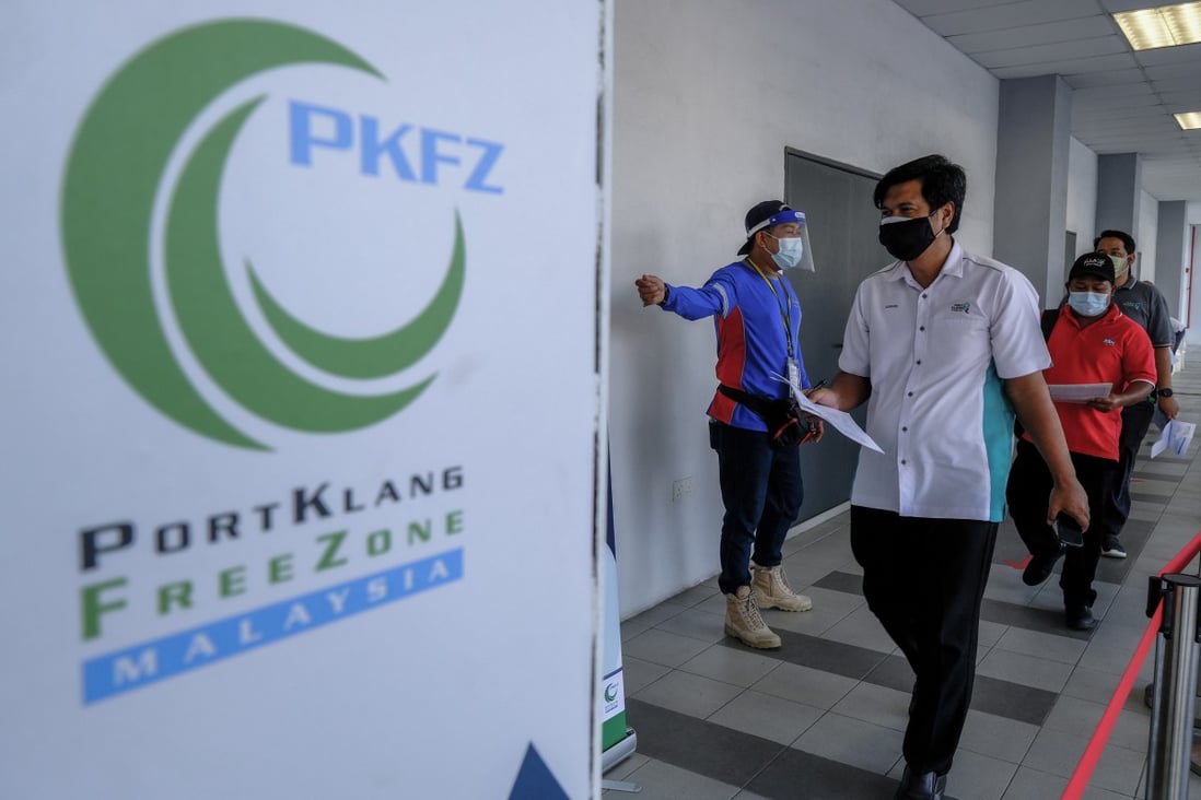 A health worker directs seafarers and port workers during a Covid-19 vaccine programme for Malaysian frontline workers in Port Klang, Malaysia, on June 25. Photo: Bloomberg