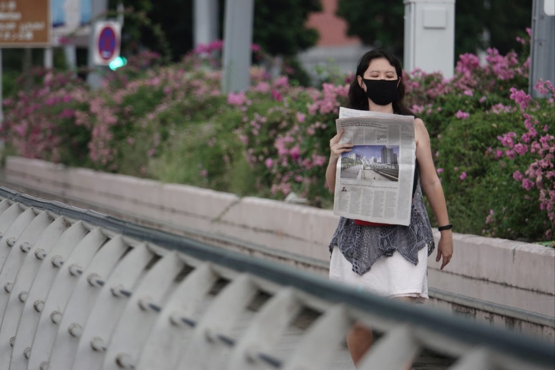 A woman reads a newspaper in Singapore. Photo: Xinhua