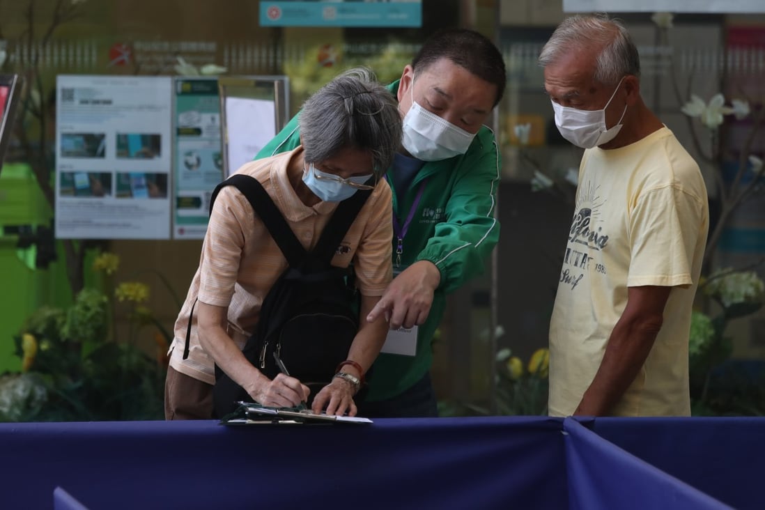 An elderly woman gets help as she fills out a form outside a Hong Kong Covid-19 vaccination centre in Sai Ying Pun on July 12. Photo: Jonathan Wong