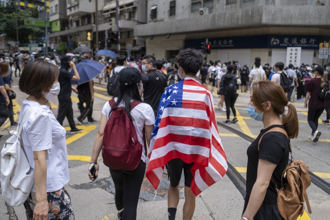 A Hong Kong demonstrator is draped in an American flag in protest against the upcoming national security legislation for the city, in Wan Chai on May 24, 2020. Photo: Bloomberg 