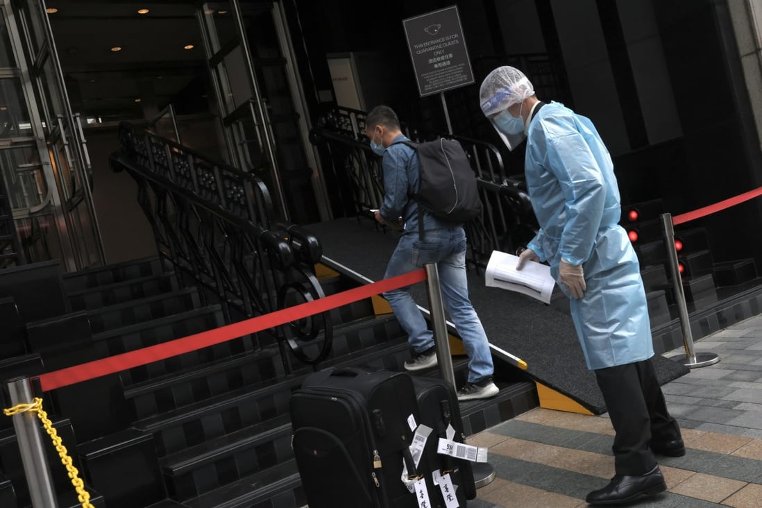 A member of staff in protective gear helps a guest  check in at a quarantine hotel in Tsim Sha Tsui on June 22. Photo: K.Y. Cheng