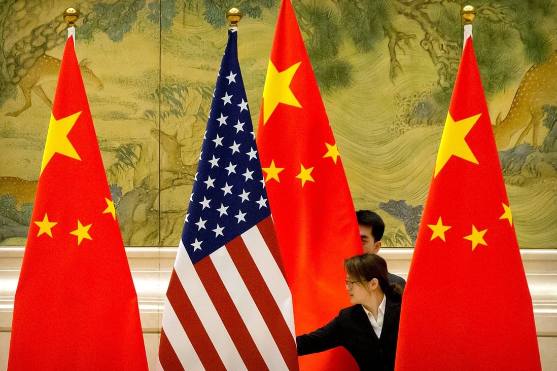 Chinese staffers adjust US and Chinese flags before the opening session of US-China trade negotiations in Beijing in 2019. Photo: Reuters