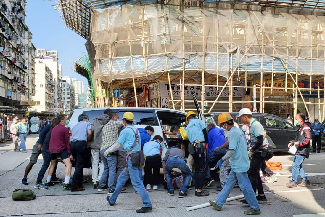 More than 10 pedestrians lifting a seven-seater car to free an elderly woman trapped underneath at the junction of Wong Chuk Street and Ki Lung Street in Sham Shui Po on December 3 last year. The driver was arrested on suspicion of causing grievous bodily harm by dangerous driving, an offence punishable by up to seven years in jail. Photo: Facebook