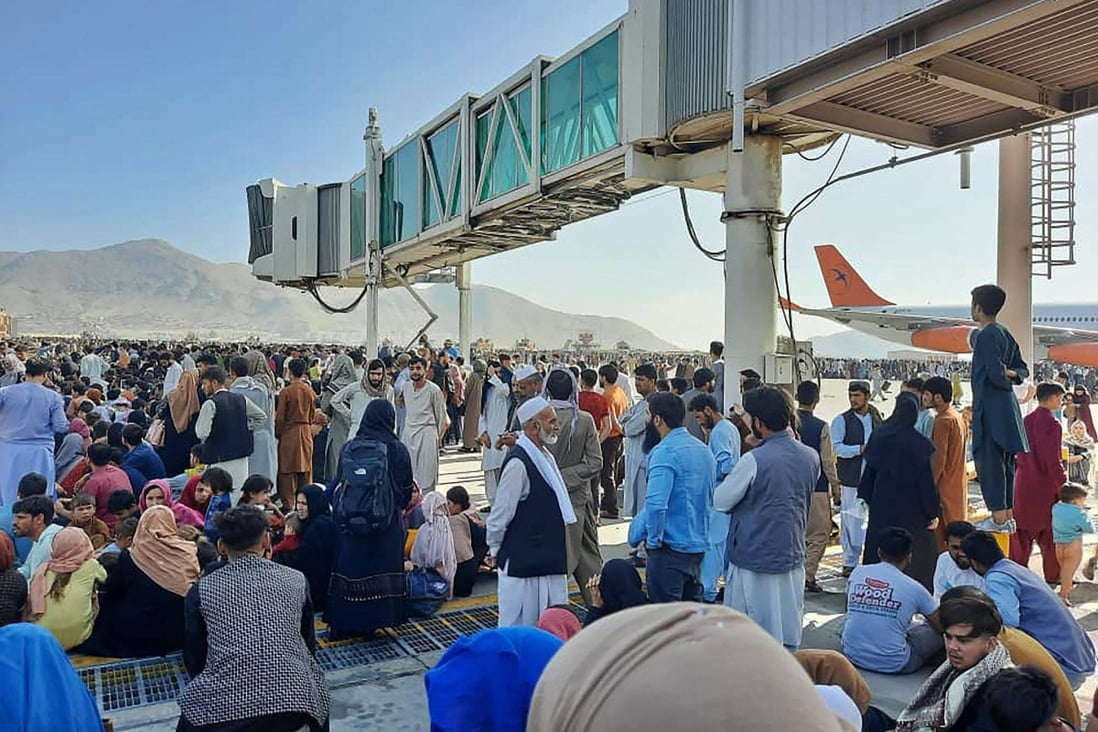 Afghans crowd the tarmac at Kabul airport on Monday as they seek to flee the country after the Taliban took control. Photo: AFP