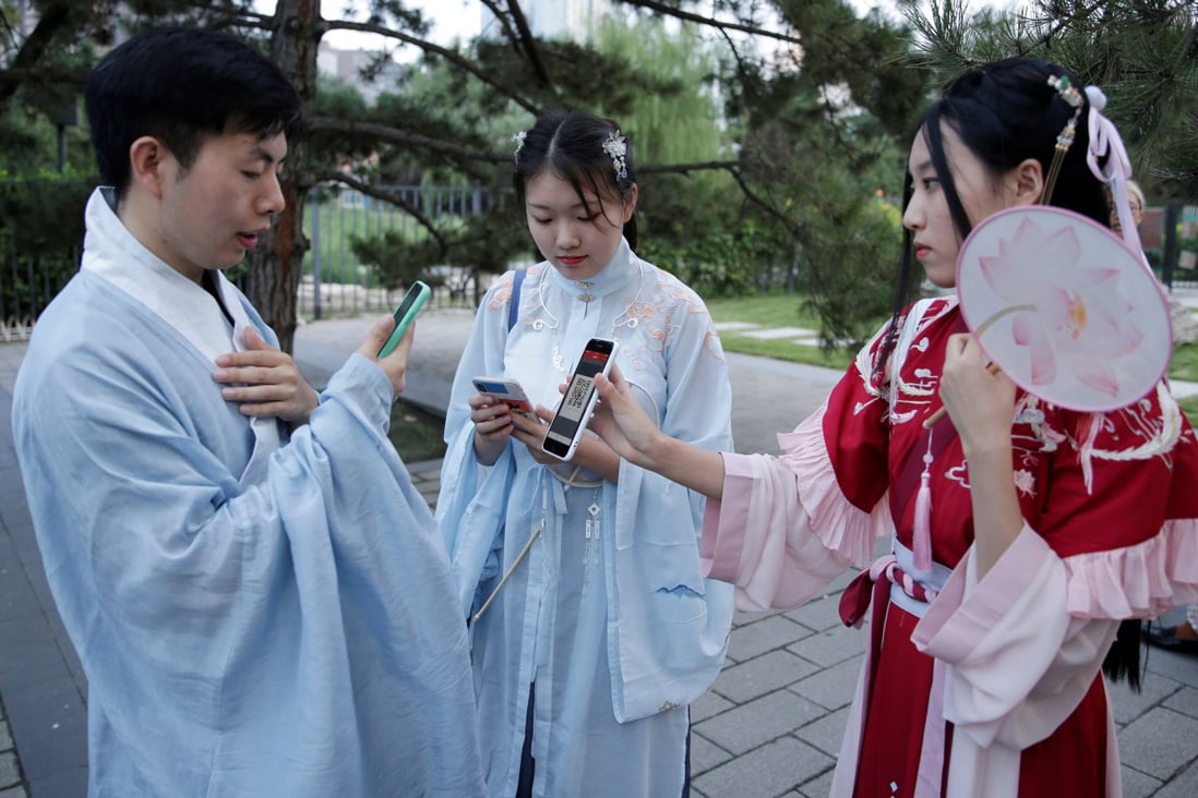 Young people dressed in hanfu use their mobile devices at an event marking the traditional Qixi festival, the Chinese equivalent of Valentine’s Day, at a park in Beijing. Photo: Reuters