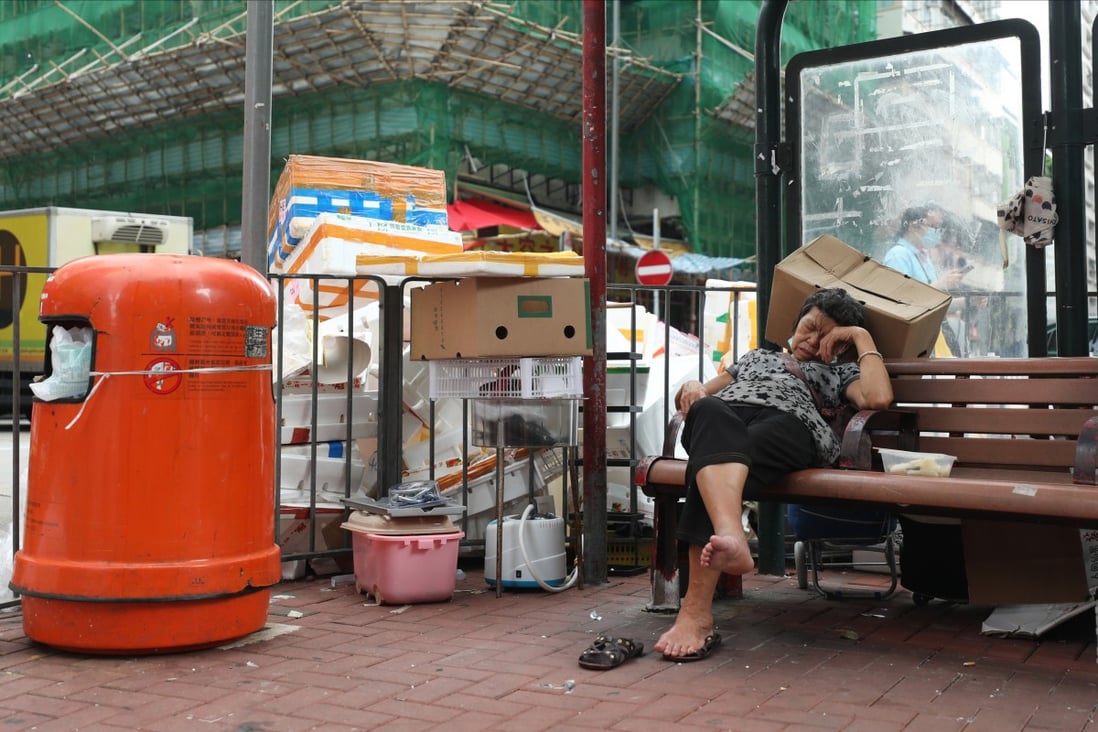 A woman sleeps on a bench in front of cardboard and styrofoam waste and a rubbish bin in To Kwa Wan on September 23, 2020. Where is the legislation to regulate overpackaging and the removal of the most harmful plastic pollutants, such as styrofoam? Photo: Xiaomei Chen