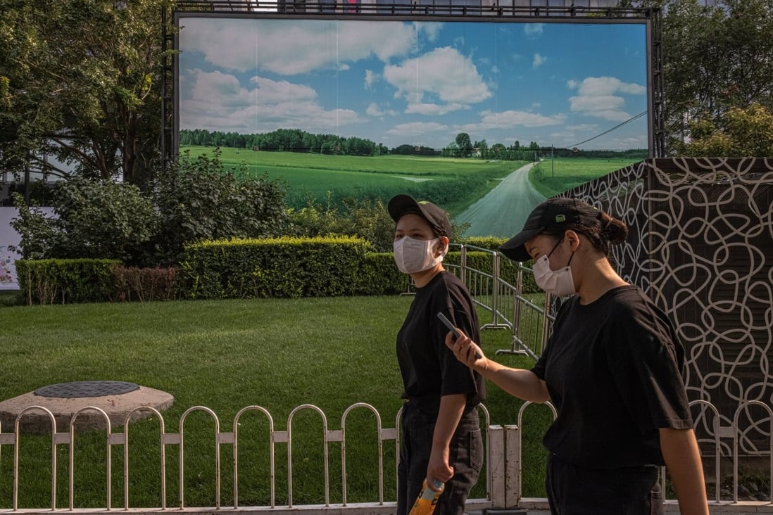 Women walk past a banner showing a green field and blue sky in the shopping and residential area of Sanlitun, in Beijing, on September 3. Beijing’s clampdown on the residential property market is much tougher than anything implemented, or contemplated, in other major economies. Photo: EPA-EFE