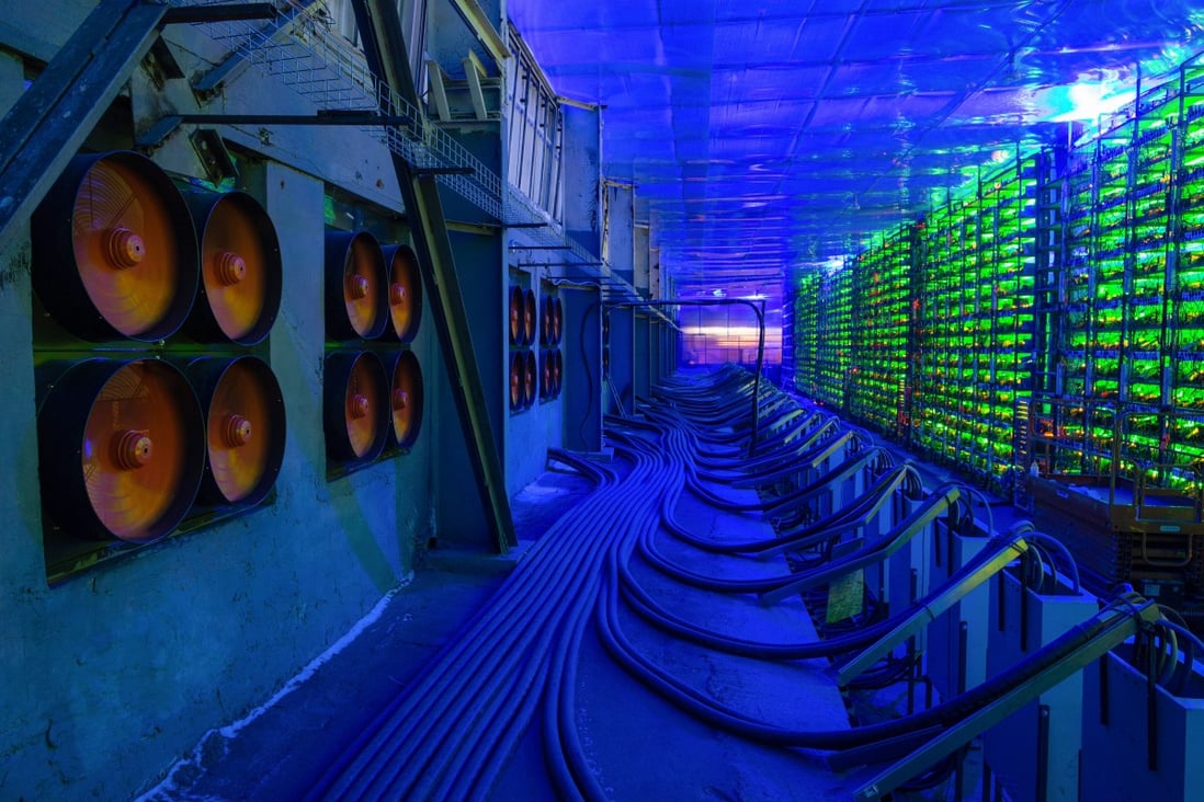 Industrial fans cool illuminated mining rigs at the CryptoUniverse cryptocurrency mining farm in Nadvoitsy, Russia. Photo: Bloomberg
