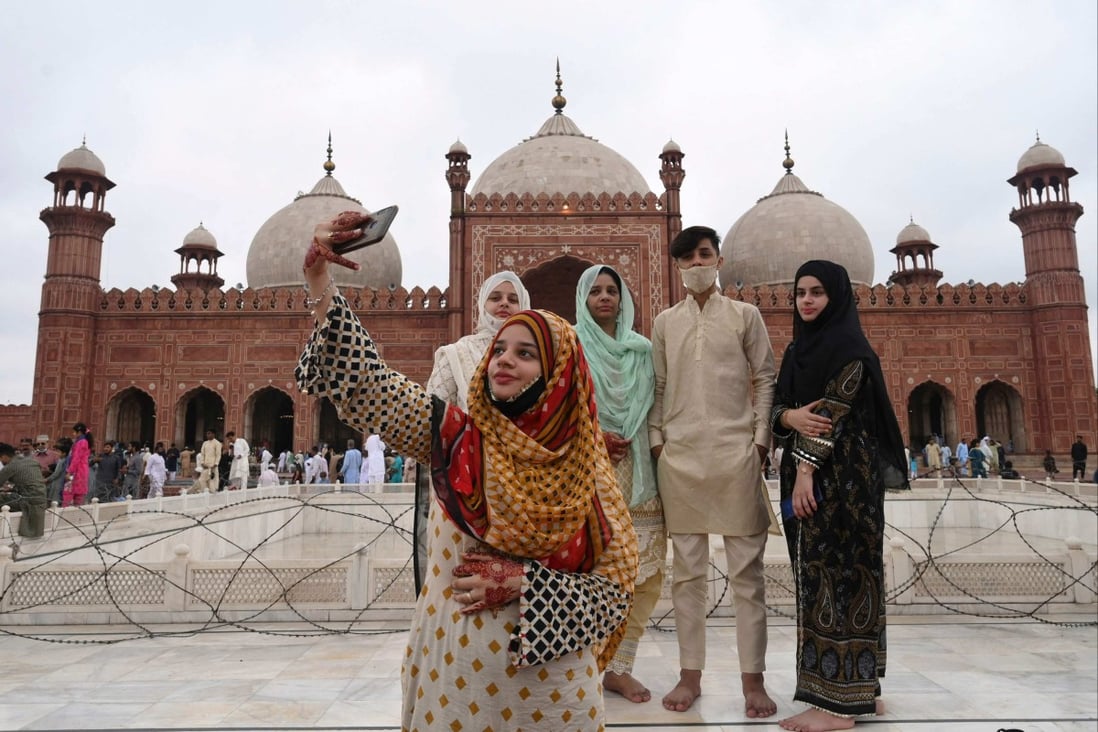 A woman takes a selfie with her friends after offering prayers at Badshahi Mosque during Eid al-Adha, the Festival of Sacrifice, in Lahore, Pakistan, on July 21. Out of Pakistan’s population of over 221 million, some 64 per cent are under the age of 30.  Photo: AFP