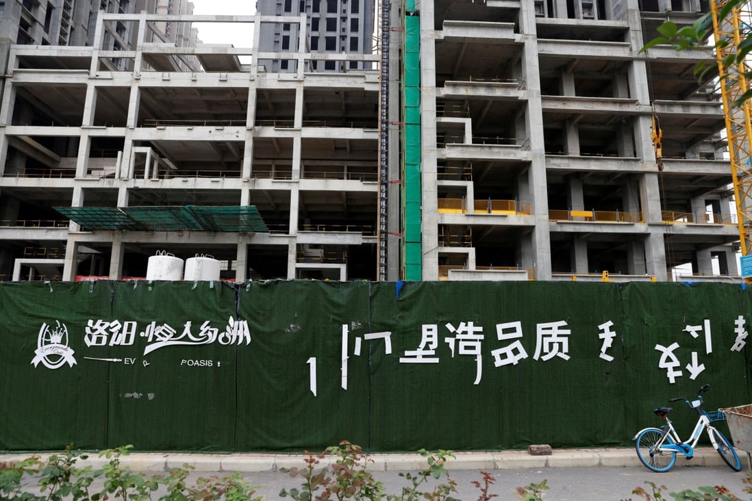 A peeling logo of the Evergrande Oasis, a housing complex developed by Evergrande Group, is seen outside the construction site where the residential buildings stand unfinished in Luoyang, Henan province, on September 16. Photo: Reuters