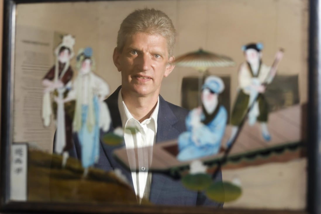 Dr Florian Knothe, director of the University Museum and Art Gallery at the University of Hong Kong, with “Taking a Boat Trip on West Lake”, one of the Chinese reverse glass paintings on display at the Reflected Beauty exhibition. Photo: Xiaomei Chen