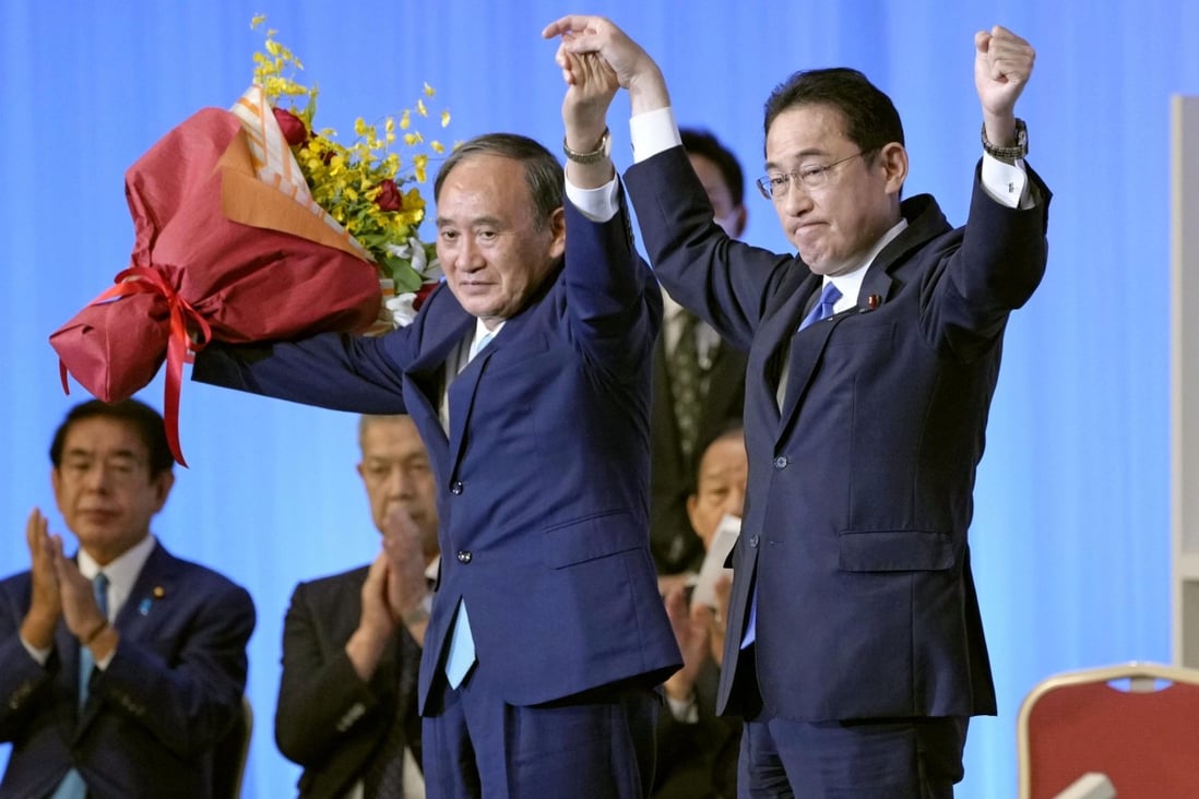 Newly elected Liberal Democratic Party leader Fumio Kishida (right) and his predecessor Yoshihide Suga stand on stage following the LDP leadership vote in Tokyo on September 29. Photo: Reuters