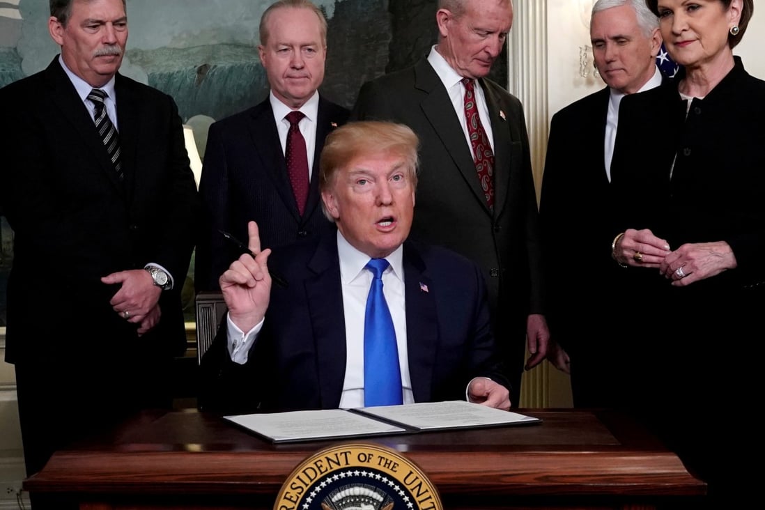 Then US president Donald Trump, surrounded by business leaders and administration officials, prepares to sign a memorandum on intellectual property tariffs on hi-tech goods from China, at the White House in Washington on March 22, 2018. Photo: Reuters